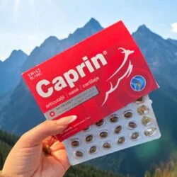 Cutie și blister cu capsule Caprin – supliment premium cu colagen natural pentru articulații, oase și cartilaje, prezentat pe fundal de munți elvețieni
